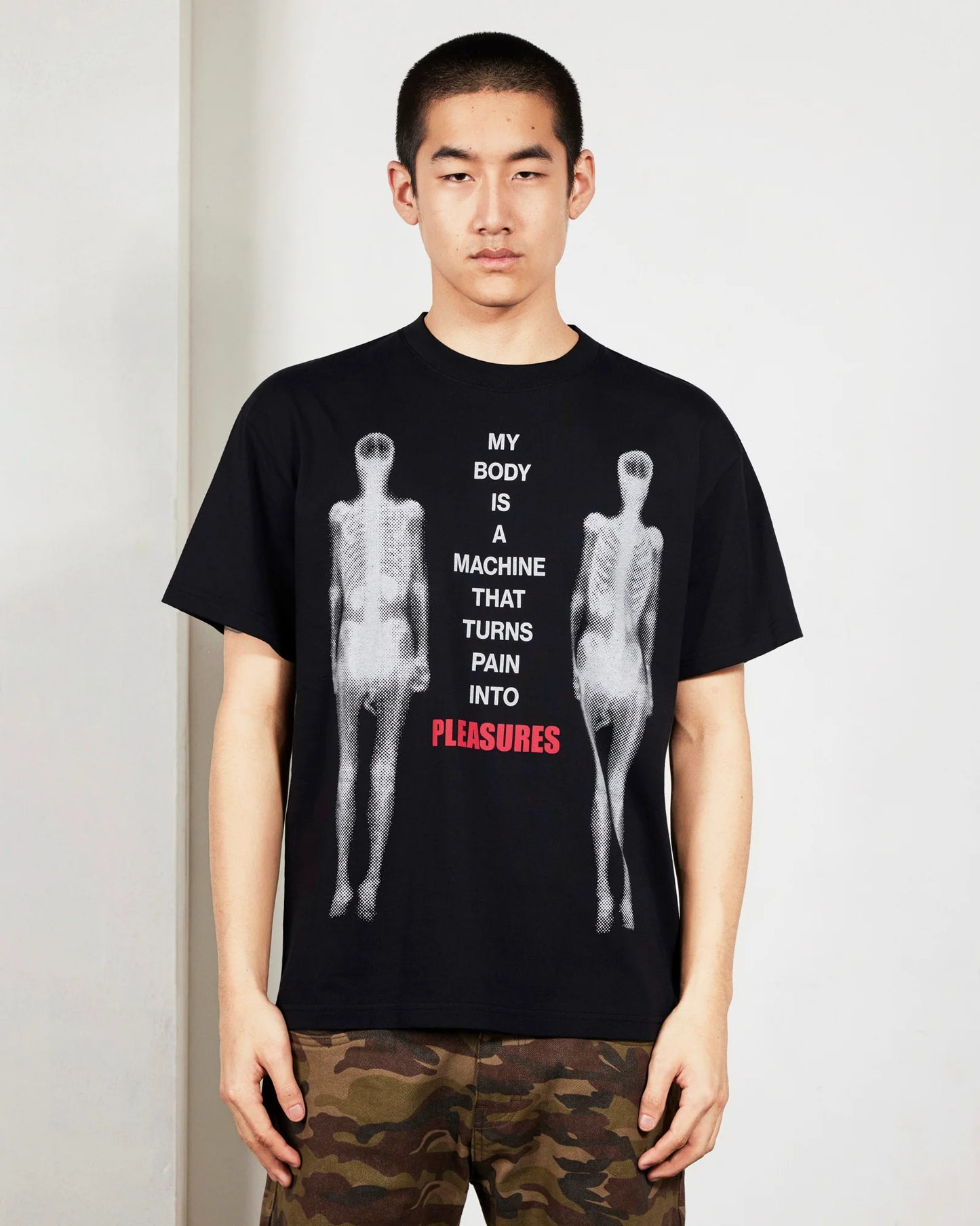 Person wearing a black t-shirt with graphic design and text.