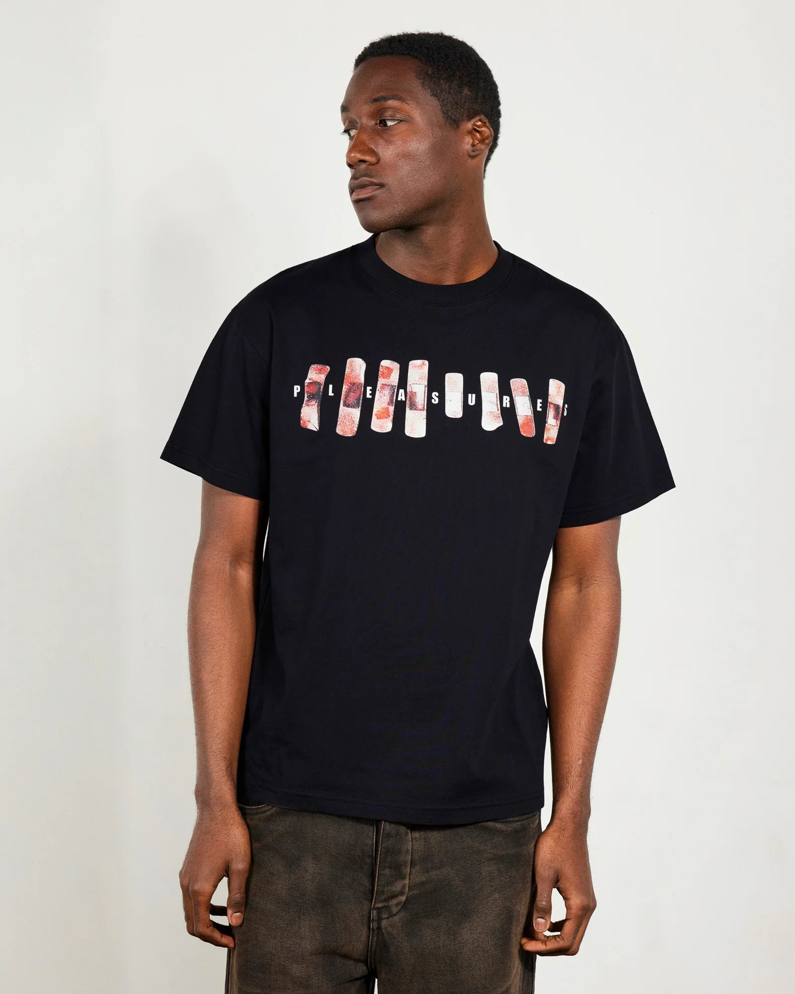 Man wearing a black t-shirt with graphic design on a plain background