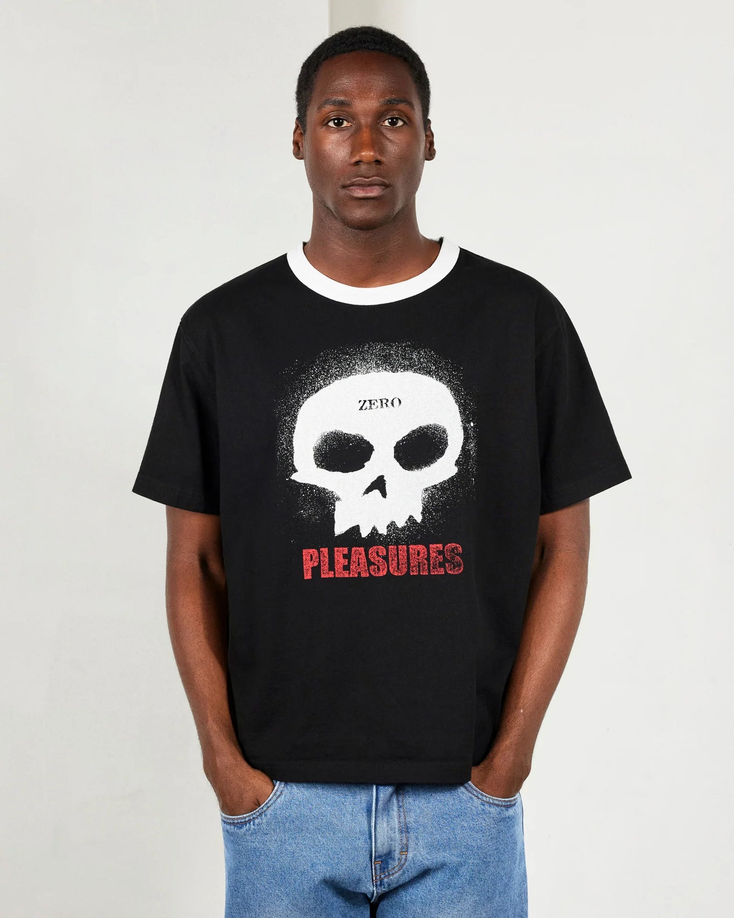 Person wearing a black t-shirt with a skull design and text on a plain background